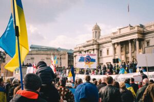 Protesters holding signs and shouting slogans during a demonstration, reflecting public unrest and demand for action."